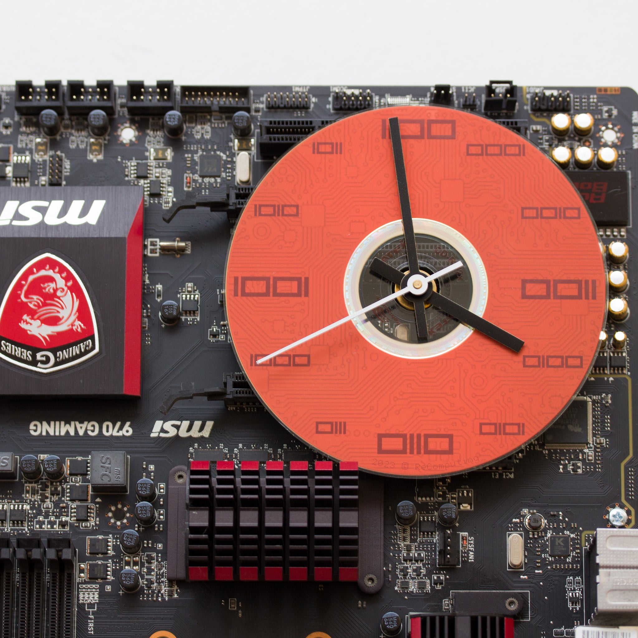 Wall Clock made of a black / dark brown circuit board with a red clock face