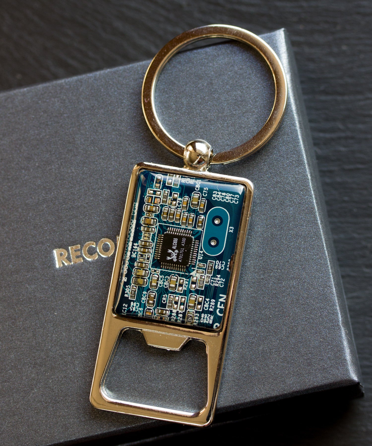 Bottle opener keychain with a circuit board piece
