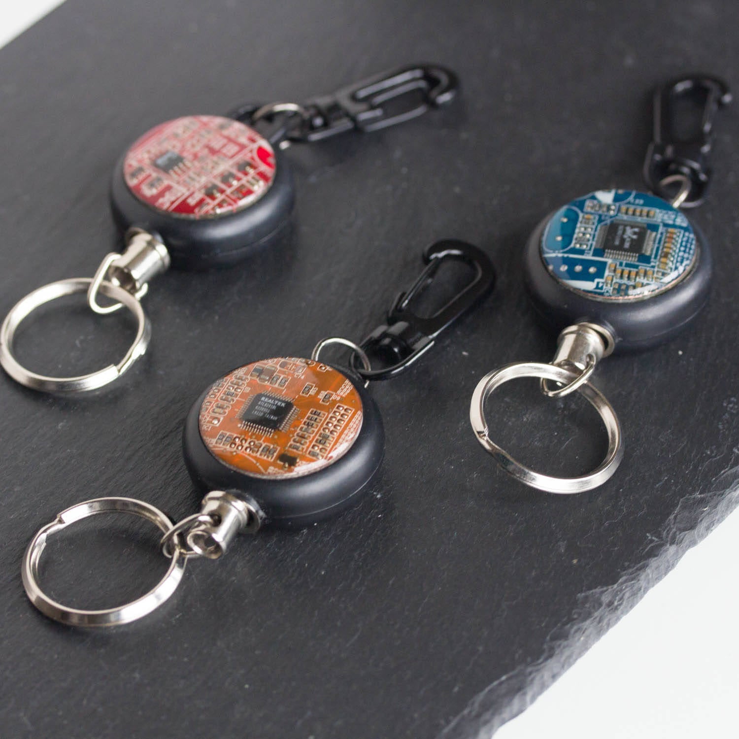 Retractable badge holder with a circuit board piece