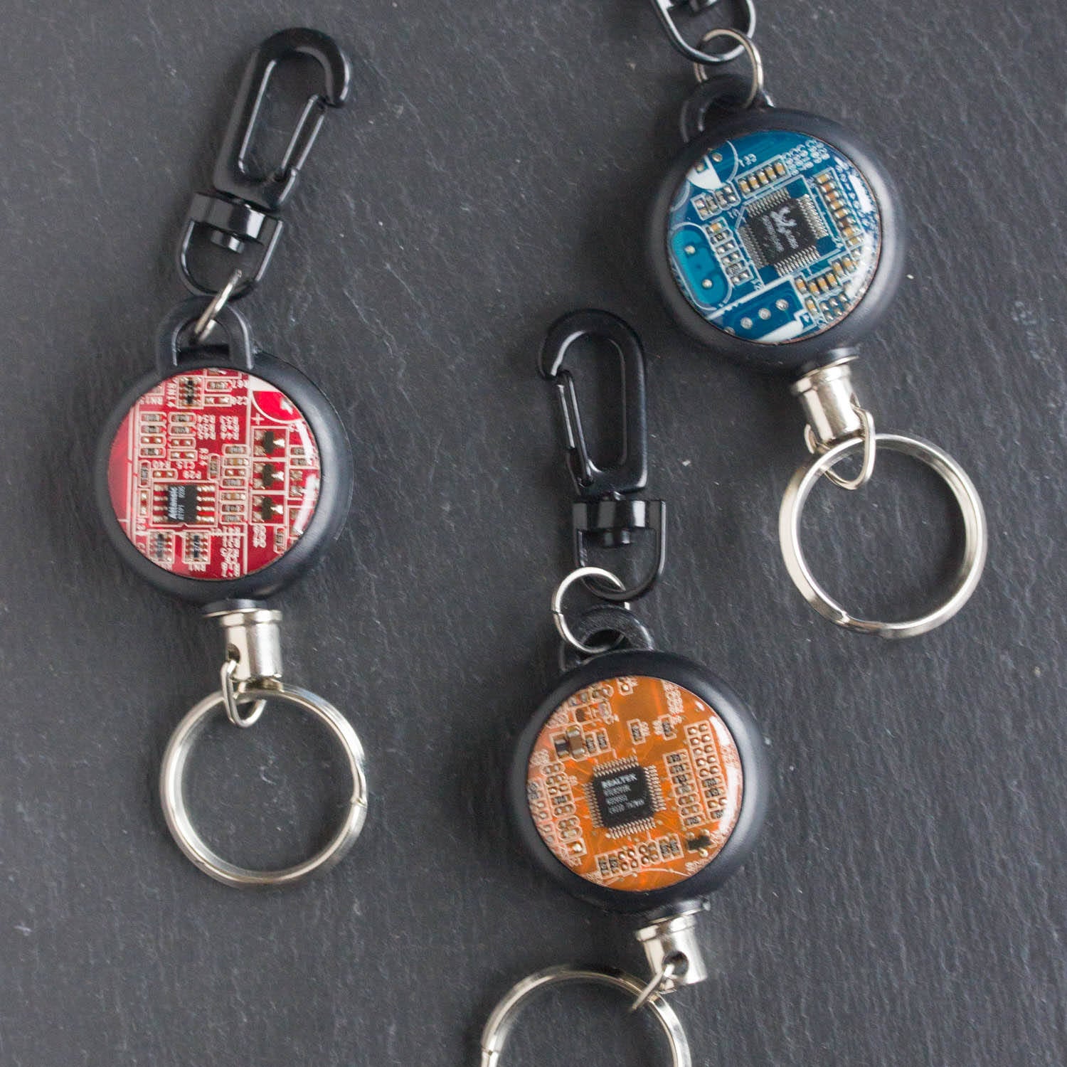 Retractable badge holder with a circuit board piece