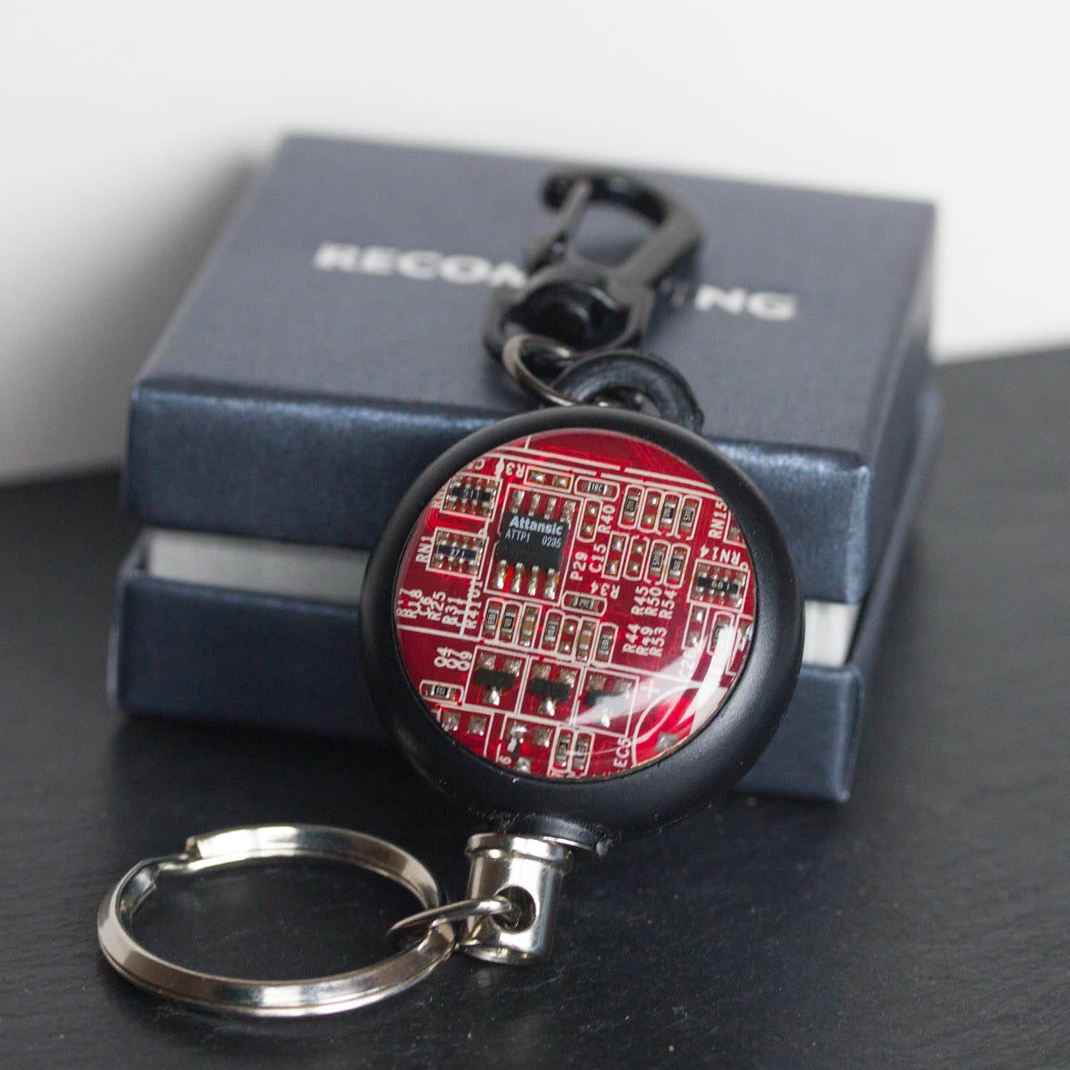 Retractable badge holder with a circuit board piece