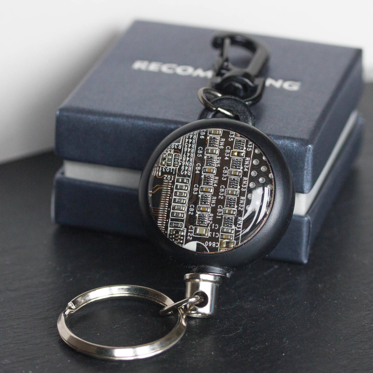 Retractable badge holder with a circuit board piece