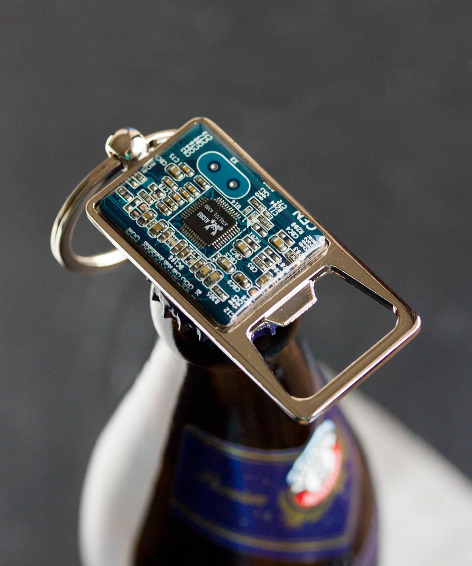Bottle opener keychain with a circuit board piece