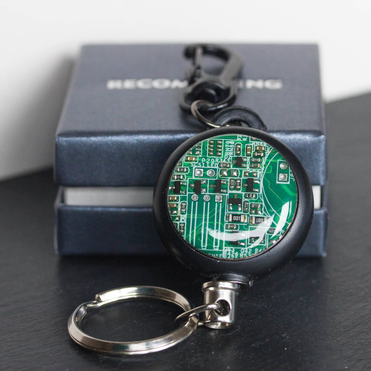 Retractable badge holder with a circuit board piece