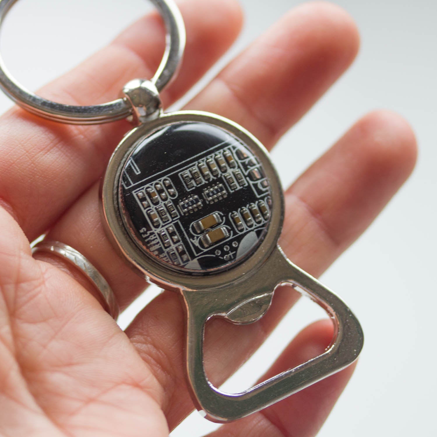 Bottle opener keychain with a circuit board